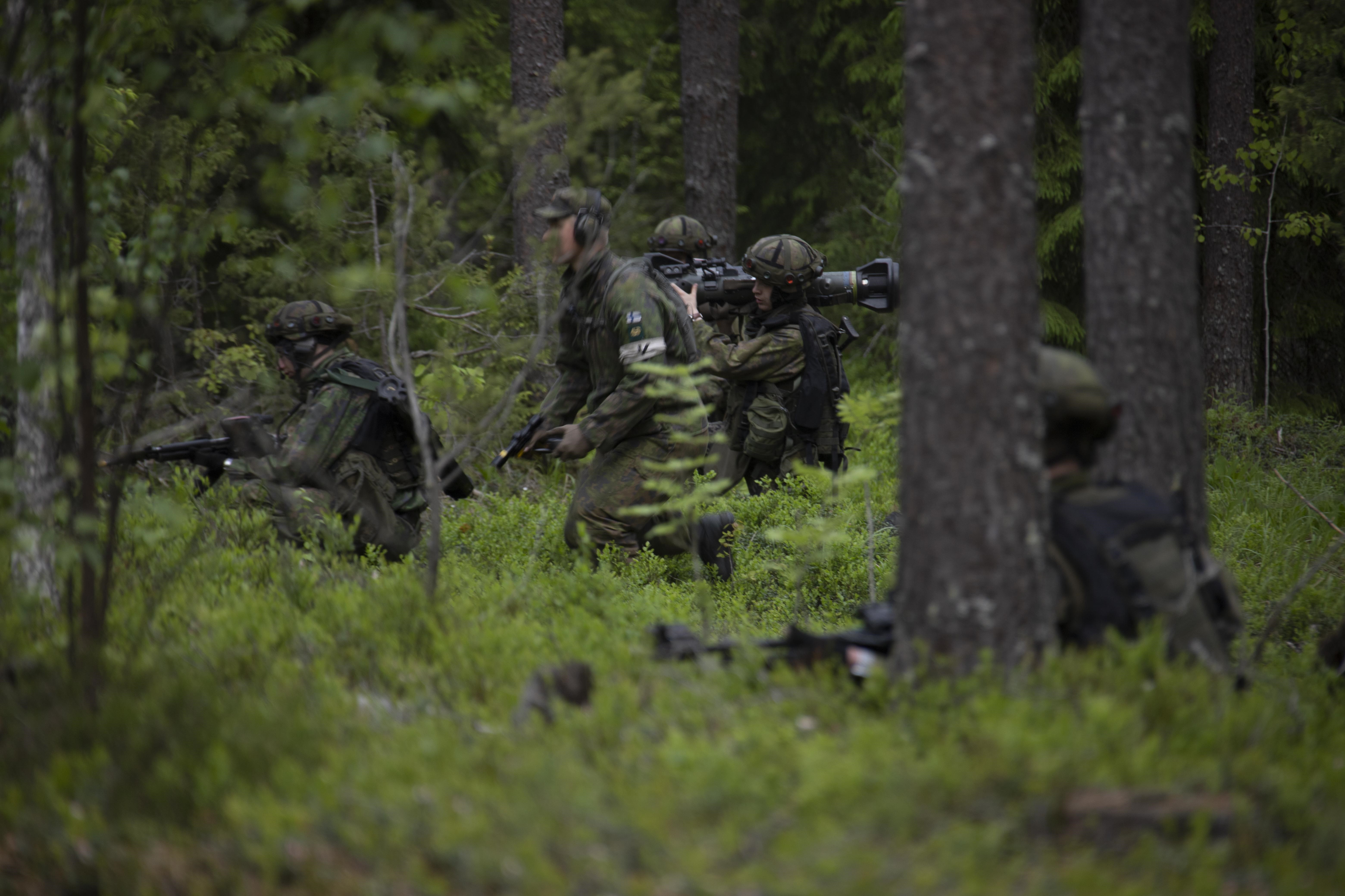 Sotilaita metsässä, osalla rynnäkkökivääri, yhdellä pistooli ja yhdellä panssarituorjuntaohjus