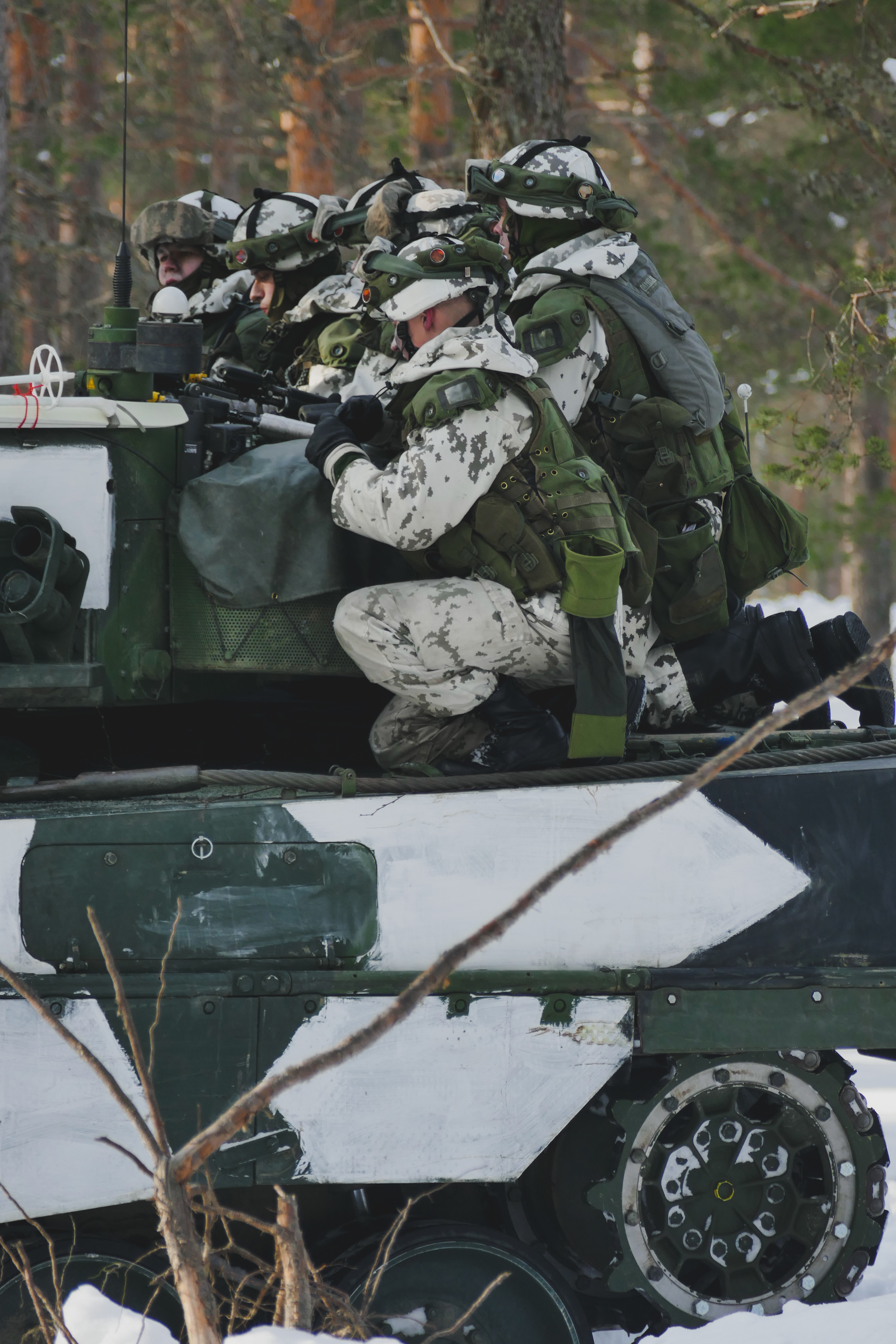 Soldiers squatting in the back of a tank