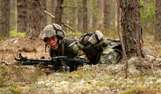 Par av kämpar som ligger i skogen. En har en maskingevär och en annan har ett anfallsgevär.