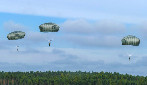 Kolme laskuvarjojääkäriä laskeutuu laskuvarjoilla