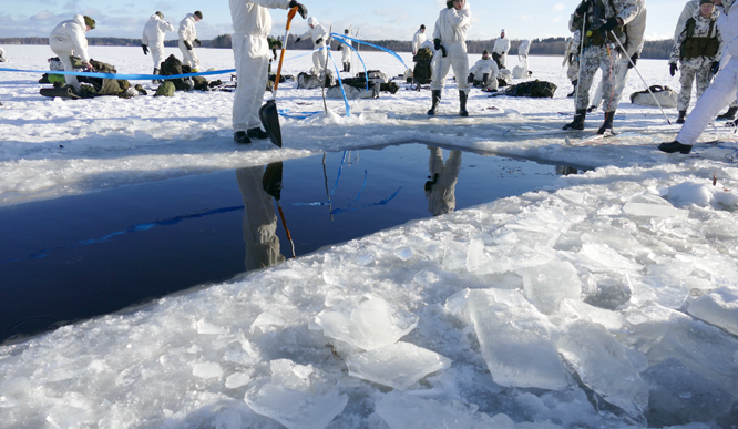 Ice hole surrounded by snow-clad soldiers
