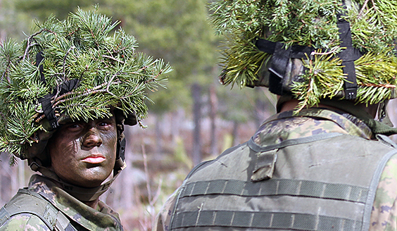Conscripts in combat equipment, helmets masked with conifers