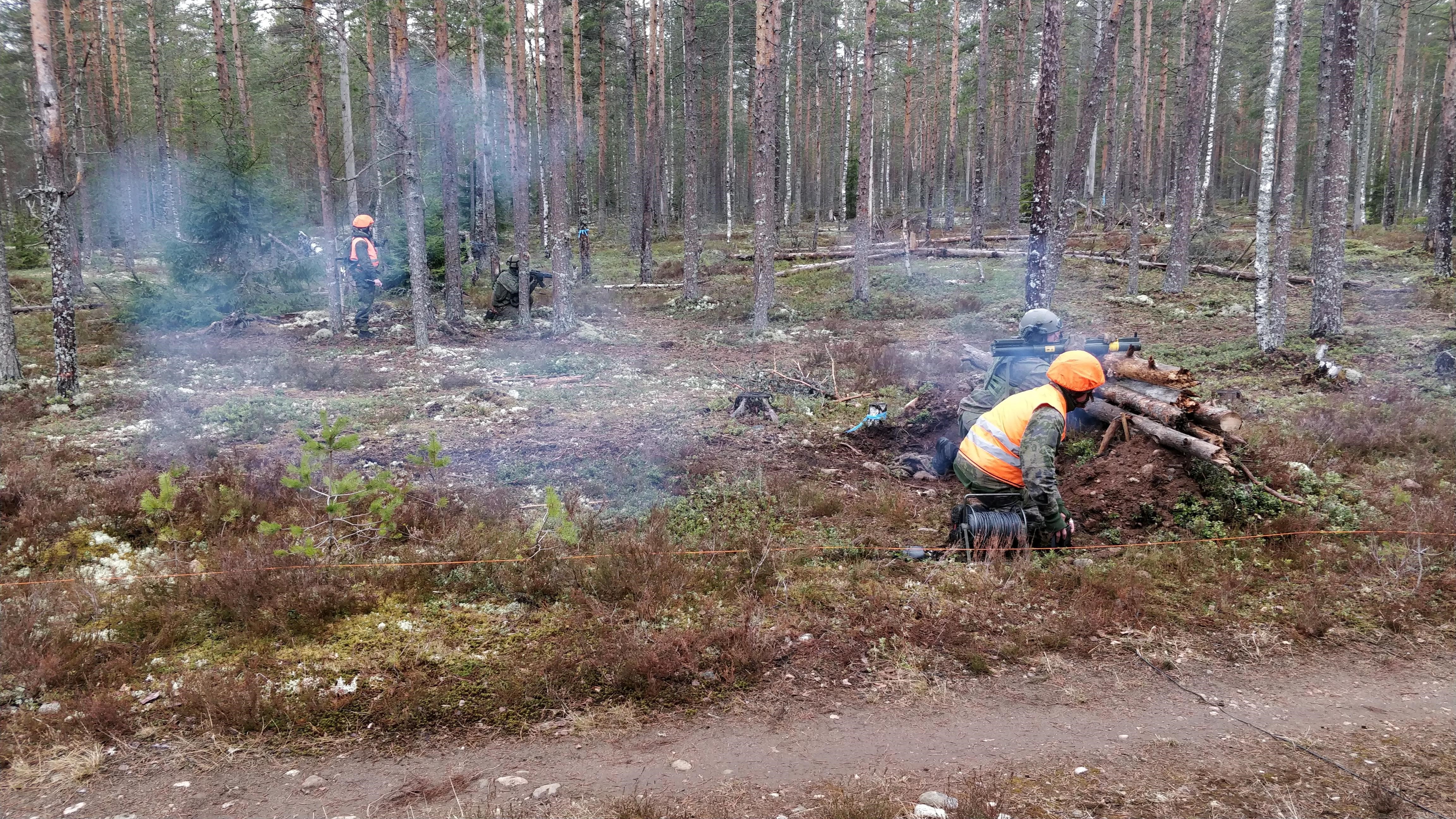 Maastossa savuaa, kun snkotaistelija on työssään tulitoiminnassa.