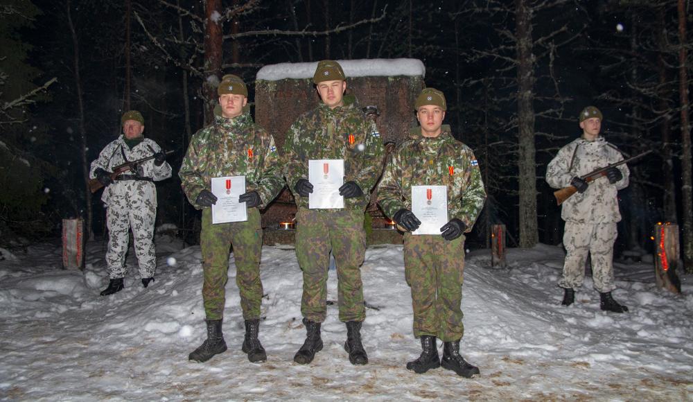 Mäntyvaaran taistelun muistomerkin edessä sotilasansiomitalilla palkitut varusmiehet.