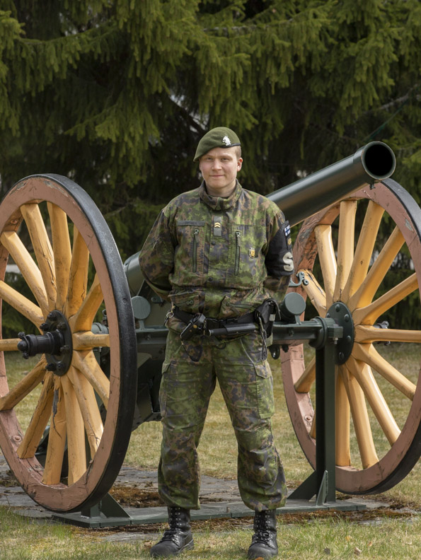 kuva, jossa alikersantti Veikka Innanen seisoo tykin vieressä