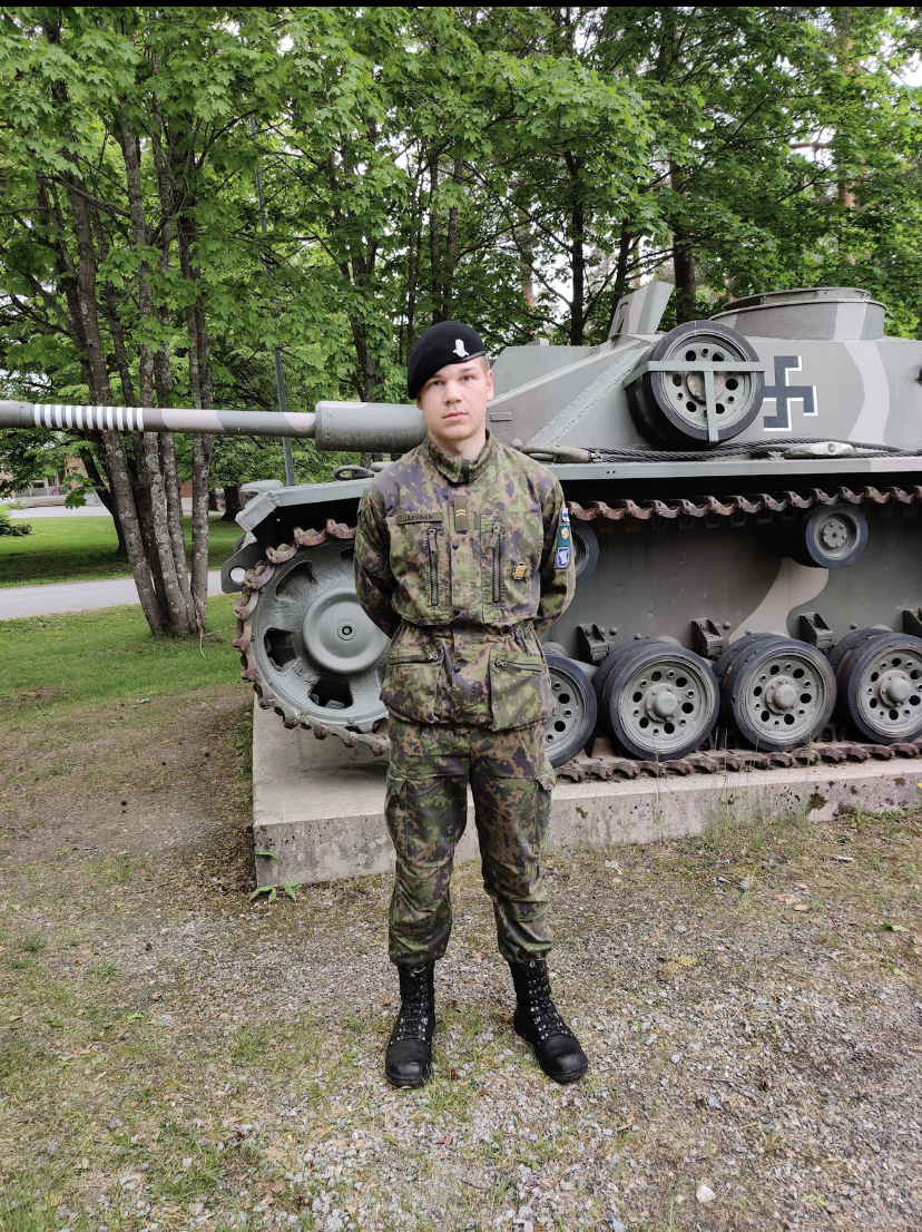 kuva, jossa alikersantti Onni Järvinen seisoo panssarivaunun edessä
