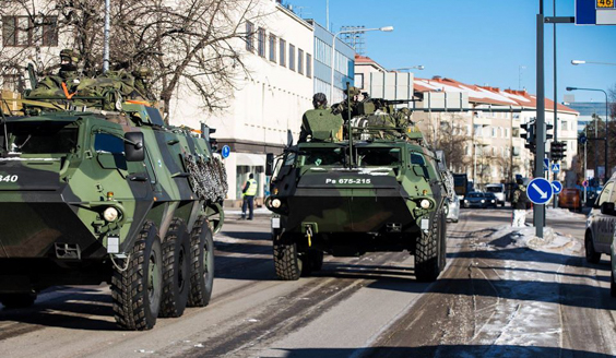 kuva, jossa panssariajoneuvoja ajaa taajama-alueella