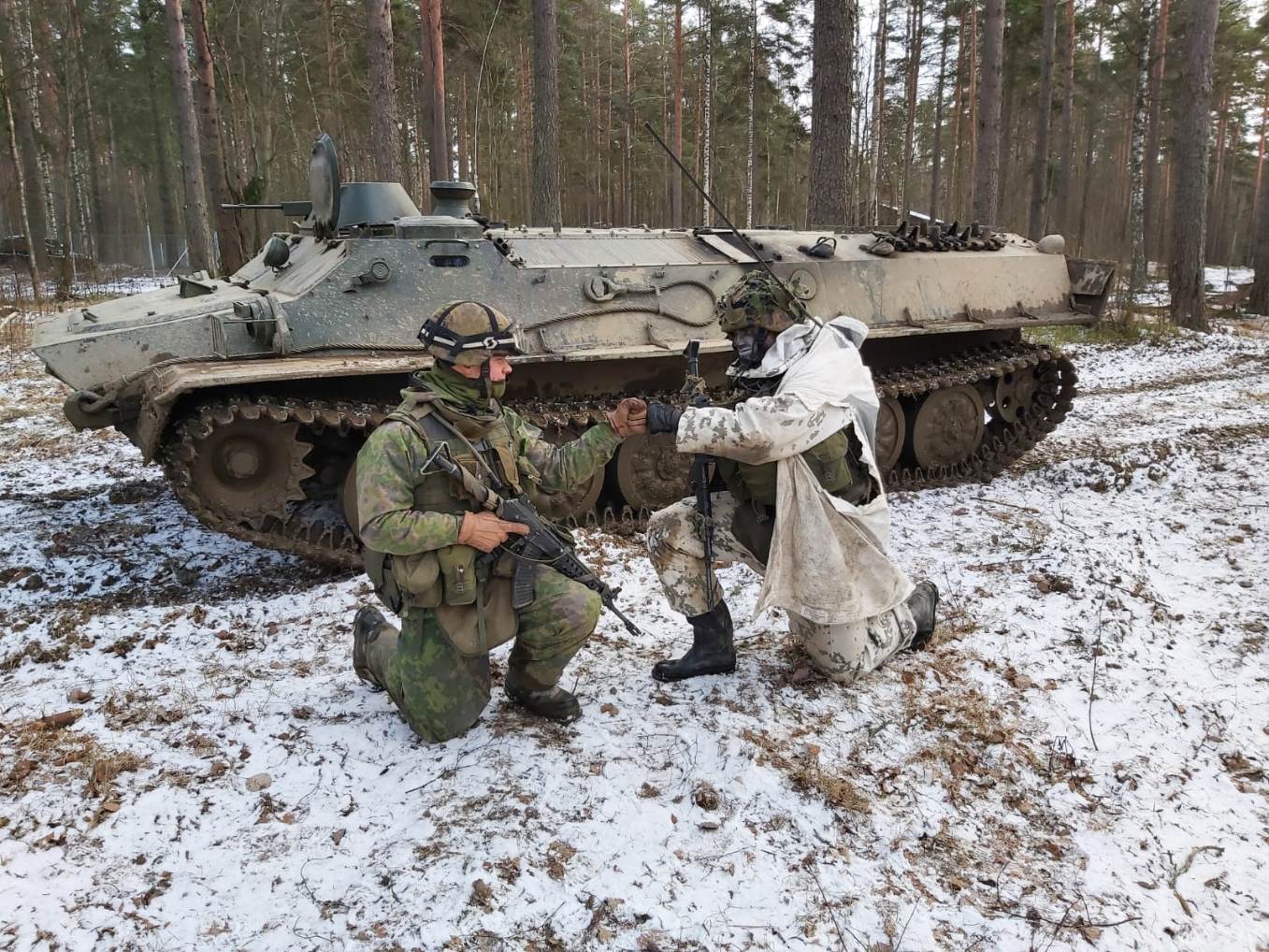 Yhteistyössä on voimaa! Panssarivaunun edessä kaksi soturia tervehtii keskenään iloisesti.