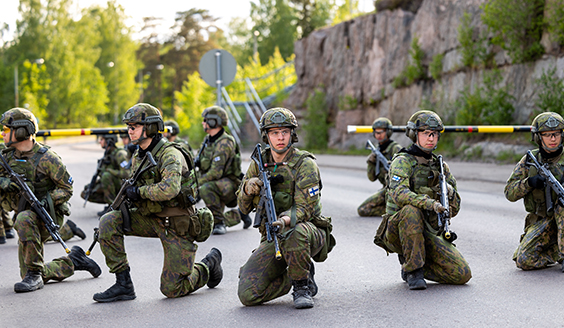 Kuvassa maastopukuisia sotilaita korkeassa polviasennossa aseet käsissään.