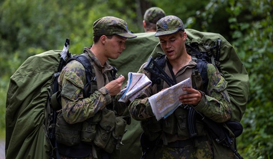 Kuvassa Urheilukoulun tiedustelijoita karttojen kanssa metsässä harjoittelemassa.