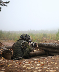 Soldaten siktar med ett anfallsgevär ur krukmakaren.