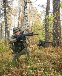 Två soldater siktar mot skogen. Den ena med ett anfallsgevär, den andra med en snigskyttegevär.