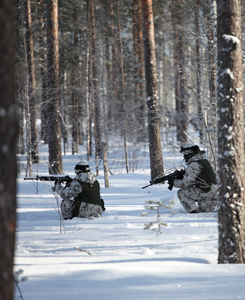 Kaksi sotilasta etenevät metsässä syvässä hangessa