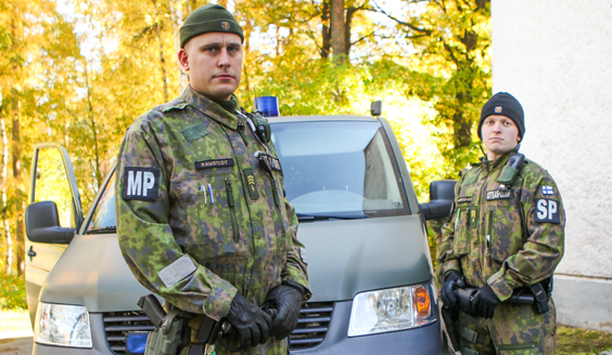 Kaksi sotilaspoliisia autonsa vieressä