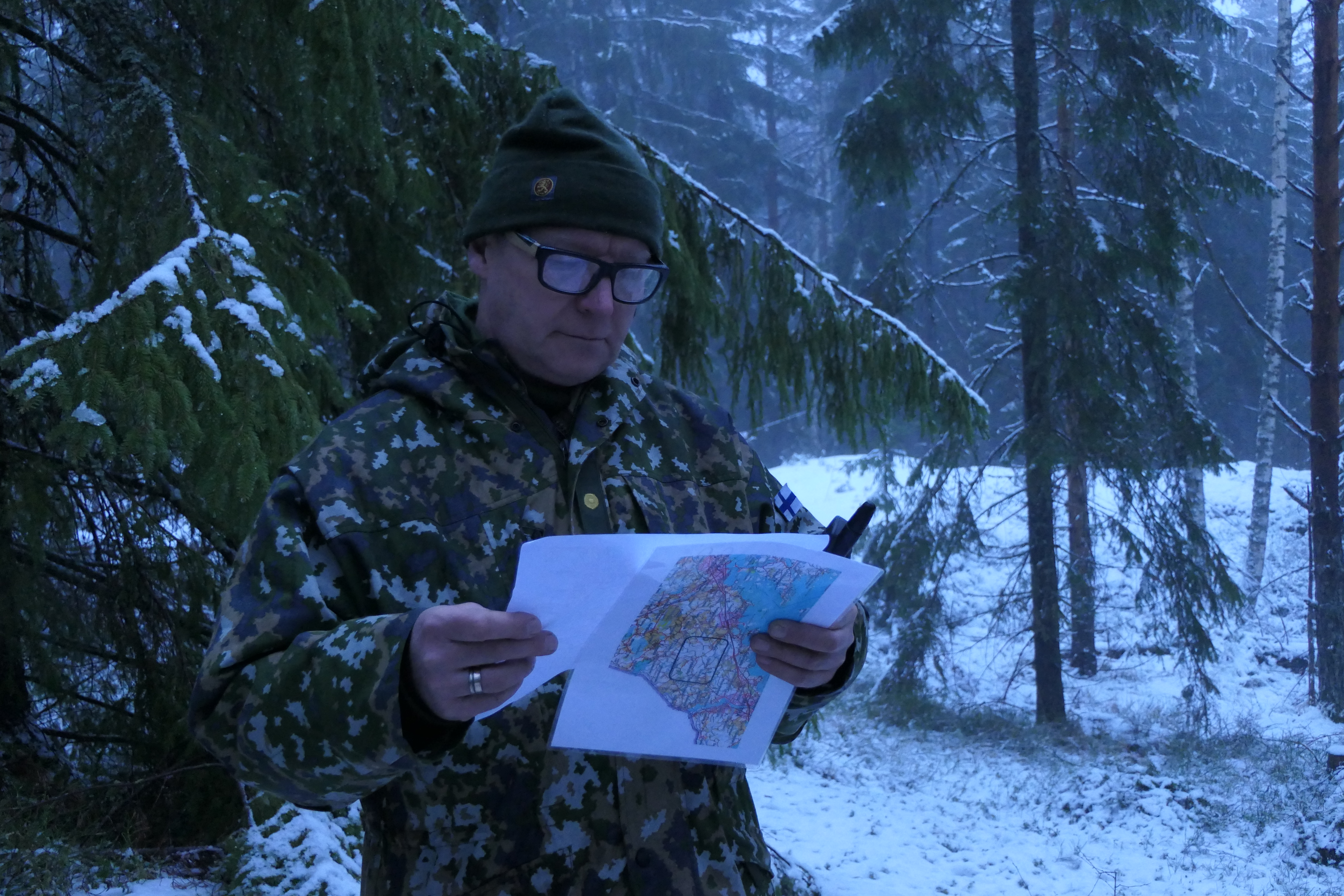 Majuri Pekka Rytkölä Maasotakoulusta tutkii karttaa Joutsenon lumisessa maastossa.