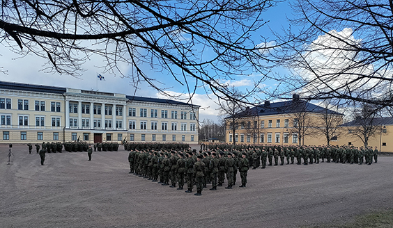sotilaita taustalla iso valkoinen rakennus, joka on reserviupseerikouluun päärakennus Haminassa