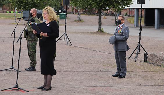 valaa esilukemassa Hanni Kangasmäki taustallaan sotilaita