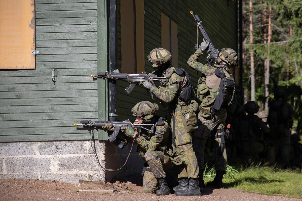 Reserviupseerikurssin sotilaspoliisilinjan upseerioppilaat harjoittelevat rakennetulla alueella taistelua. Oppilaat ovat aseineen talon ympärillä ja varmistavat rakennuksen kulmat.