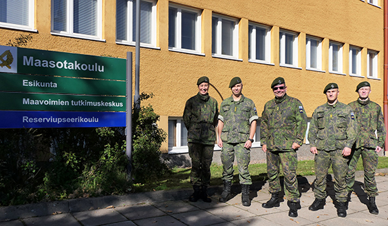 Reserviupseerikoulun neljä sotilasta ja koulunjohtaja Helminen varuskunta-alueella, taustalla näkyy Josafatinlaakso ja Reserviupseerikoulun päärakennus.
