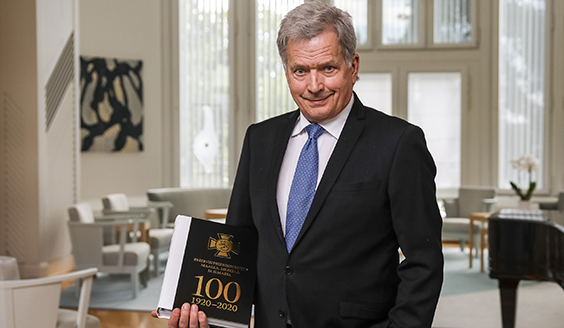 Presidentti Sauli Niinistö kädessään RUK 100 -juhlakirja.