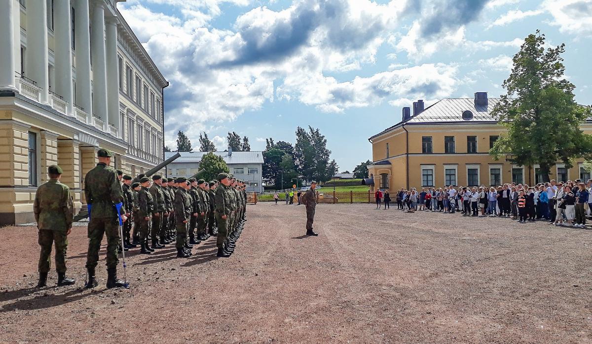 Varusmiehet rivissä RUK:n päärakennuksen edessä. Vastapuolella on heidän läheisiään.