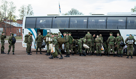 varusmiehiä tavaroiden kanssa bussin edessä