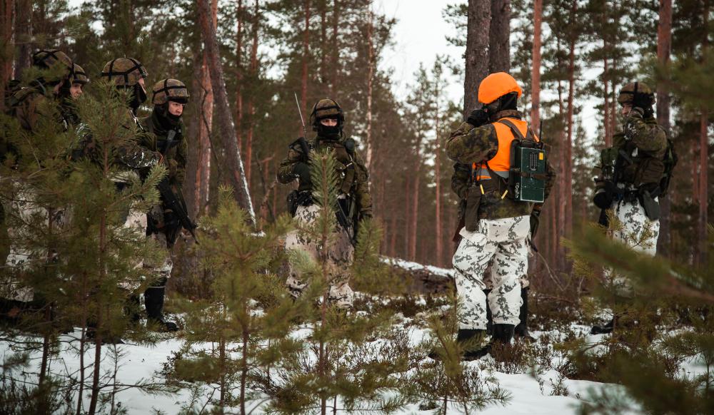 Kolme sotilaspoliisia poistumassa juosten rakennuksesta Salo 21 -paikallispuolustusharjoituksen ammunnoissa.