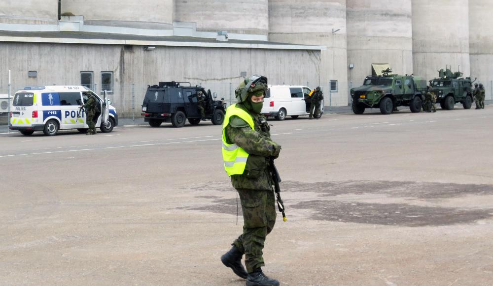 Kuvassa etualalla sotilaspoliisi ja taustalla puolustusvoimien ja poliisin ajoneuvokalustoa Rauman satamassa.