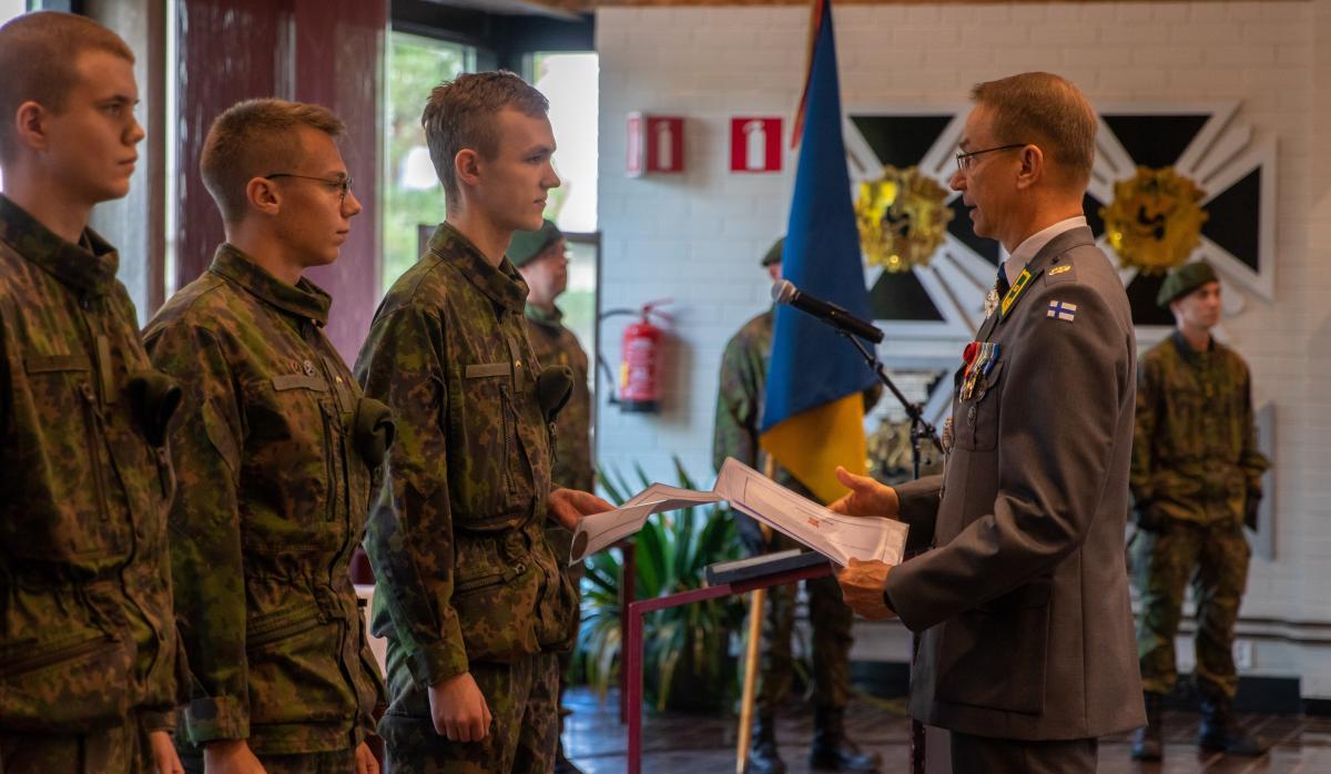 Kuvassa kotiuttamisjuhlassa palkittuja varusmiehiä ja Porin prikaatin komentaja ojentamassa palkintoja.