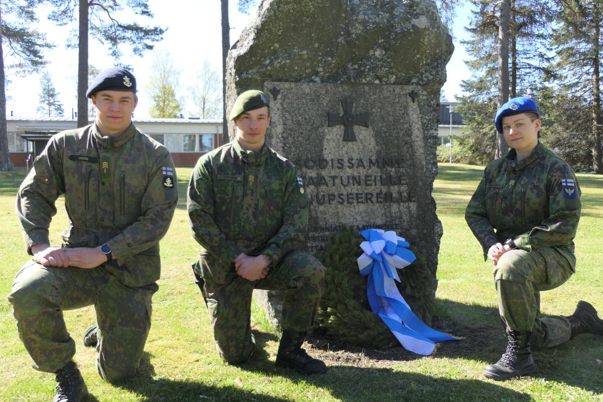 Polviasennossa maastopuvussa kolme sotilasta eri puolustushaaroista eli erivärisissä bareteissa.