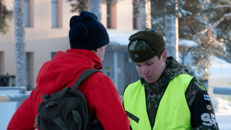 Sotilaspoliisi ja palvelukseen tulossa oleva henkilö