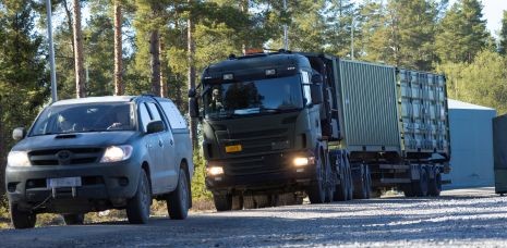 Maastohenkilöauto ja ajoneuvoyhdistelmä tiellä.