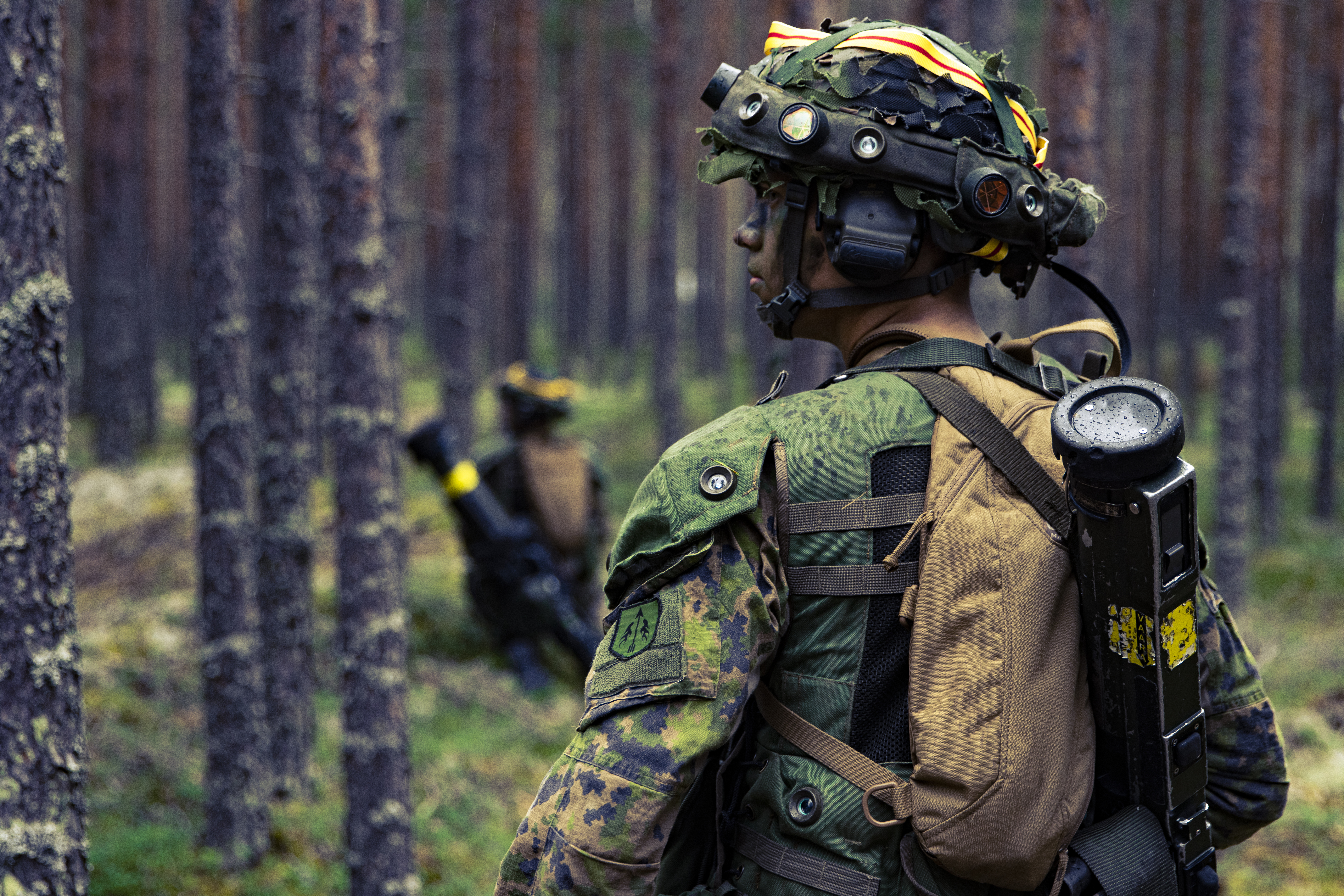 Kevytsingolla varustettu sotilas metsässä. 
