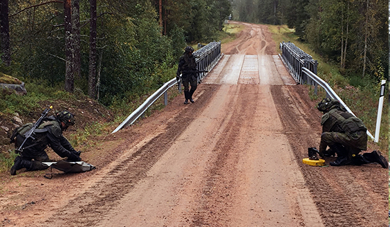 Sotilaat asettavat miinoja tielle