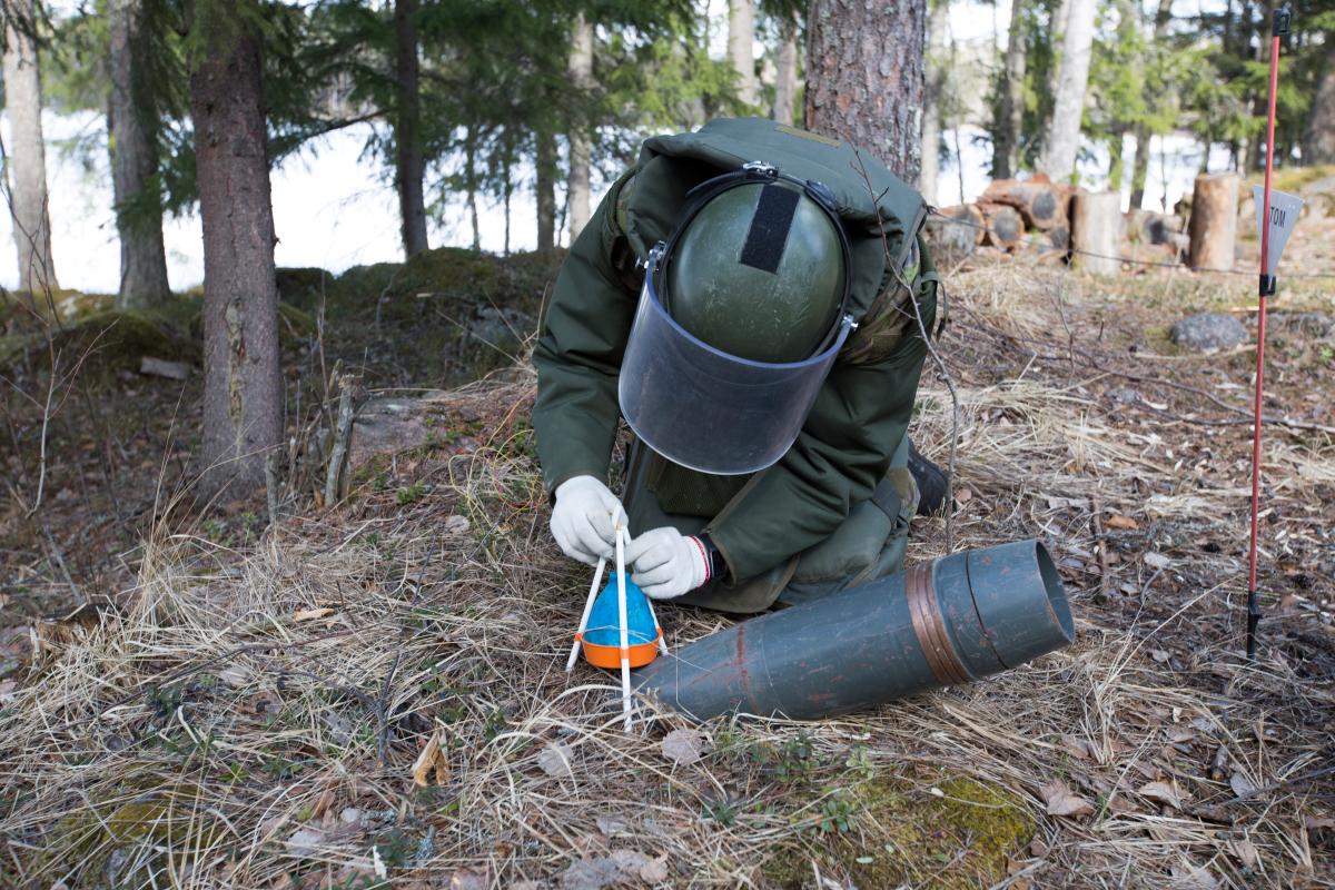 Raivaaja asettaa sinisen pussin räjähteen päälle