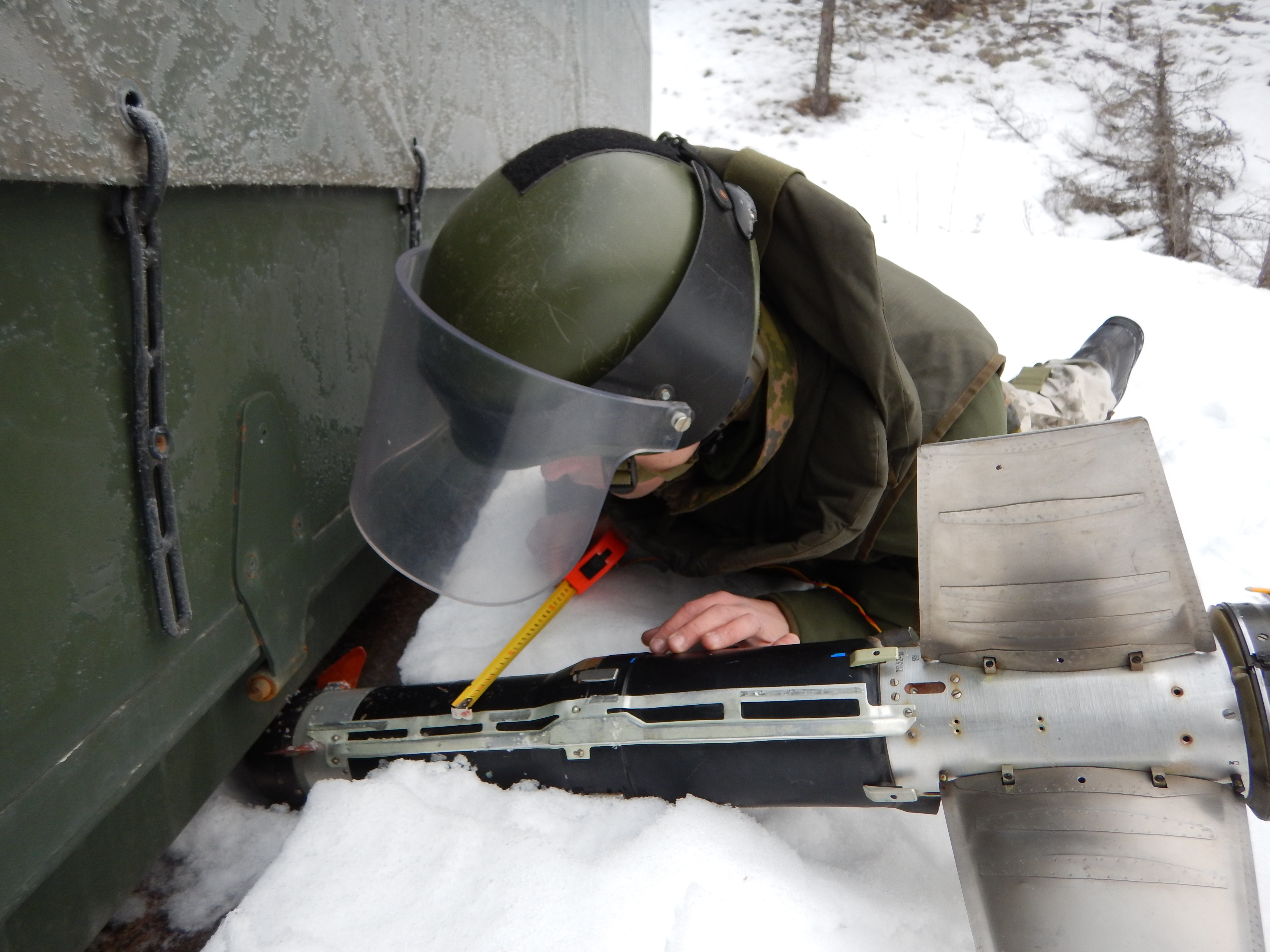 The clearer measures the width of the bomb with a tape measure