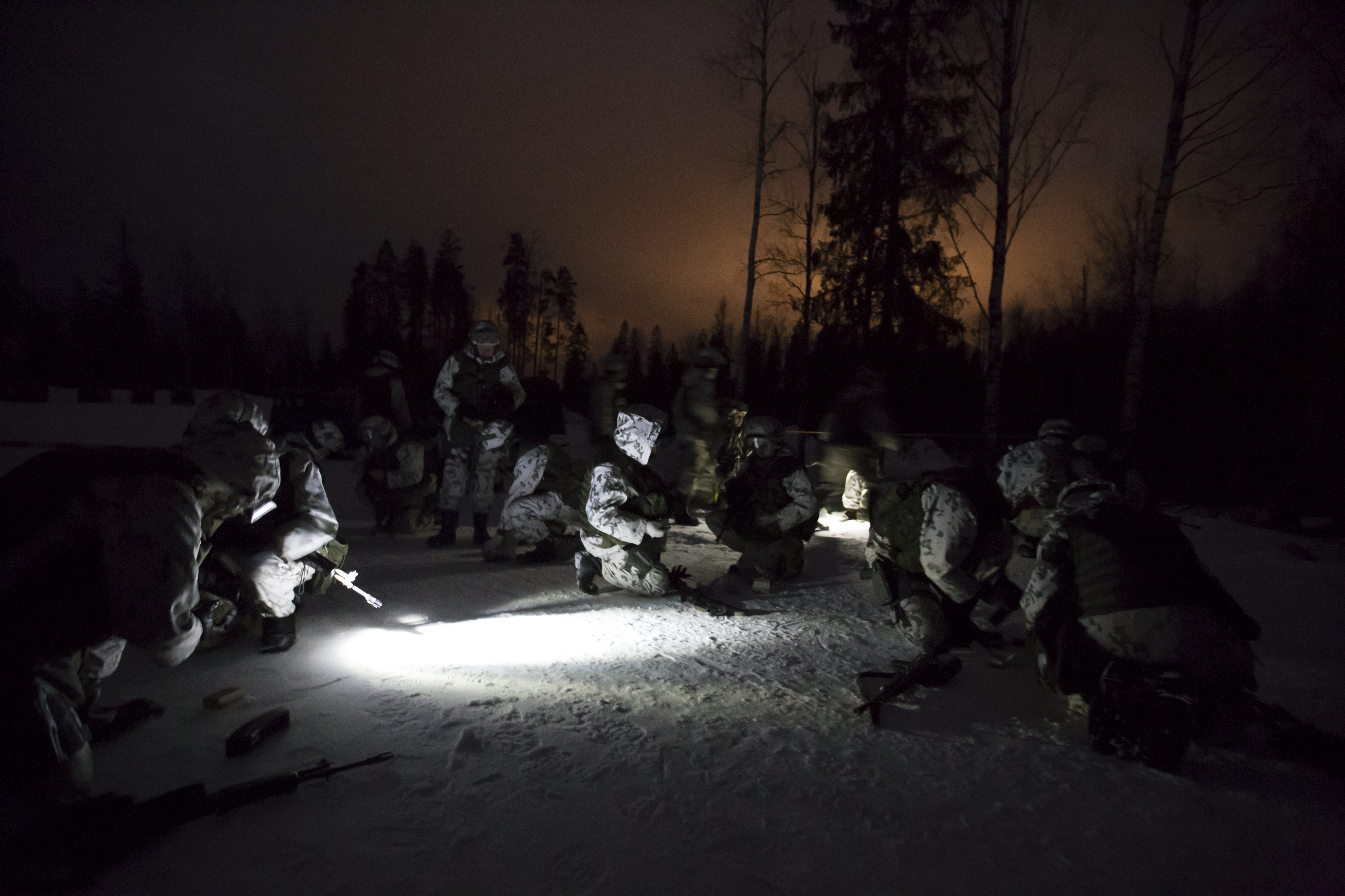 Sotilaita lumisessa metsässä pimeällä
