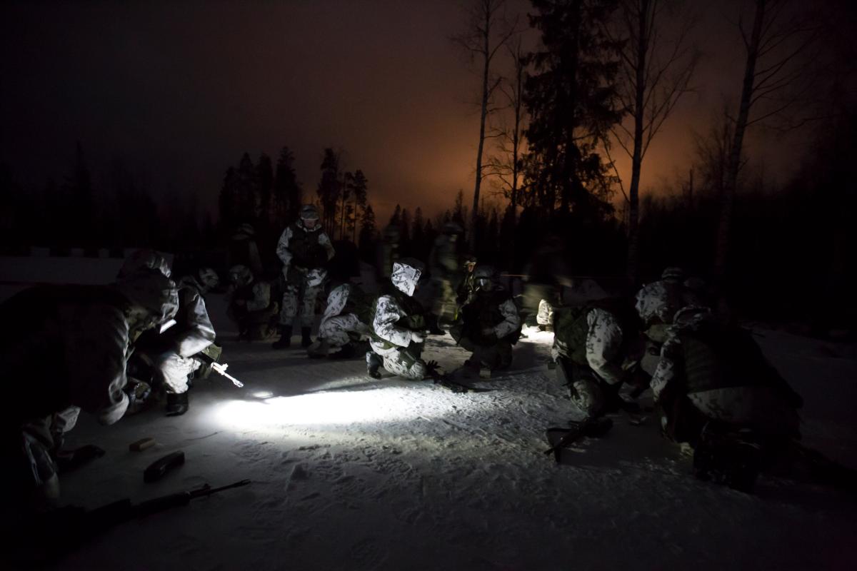 Sotilaita pimeässä lumisessa metsässä