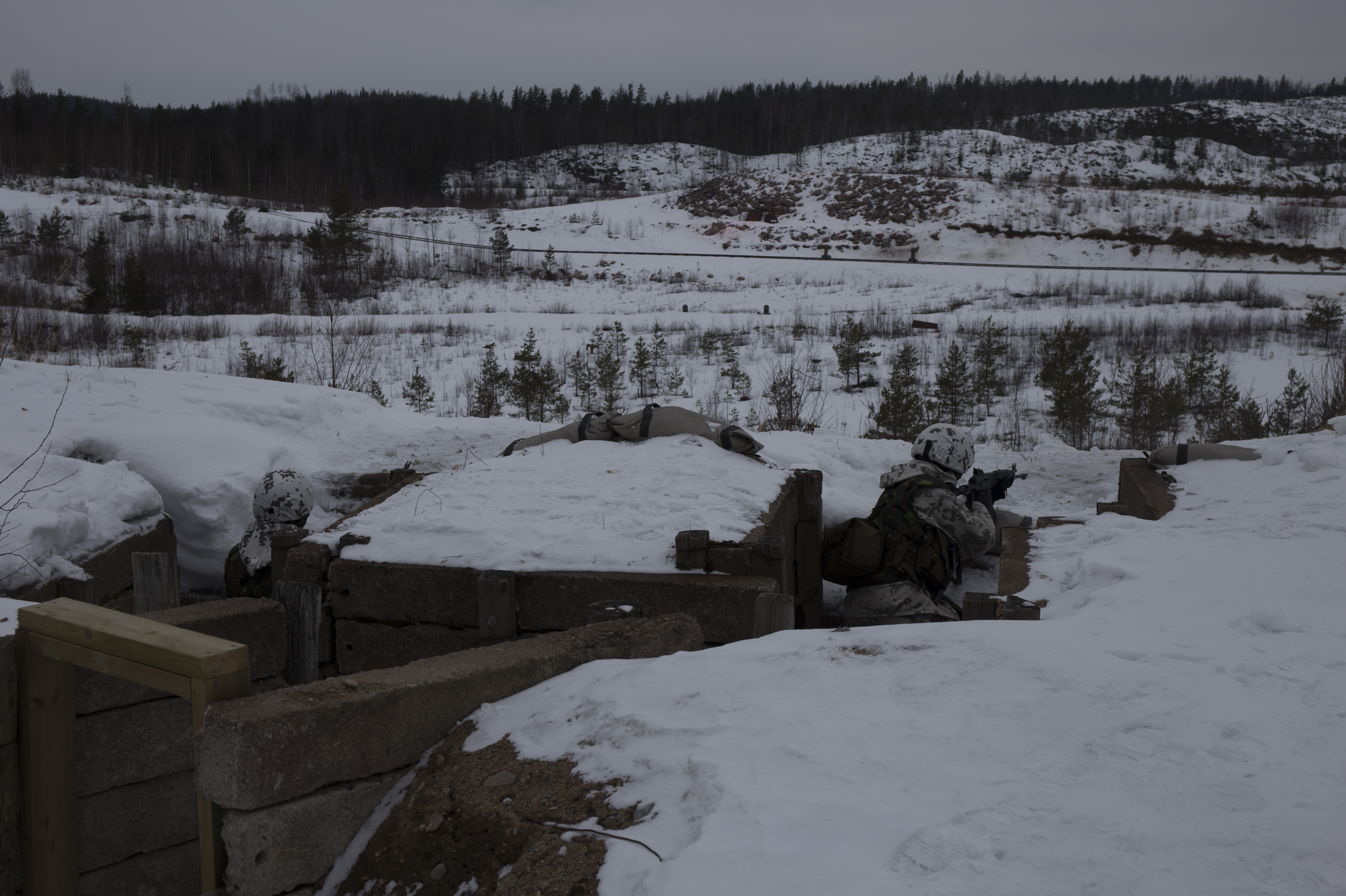 Sotilaat tähtäilevät tuliasemista lumiseen aukeaan maastoon