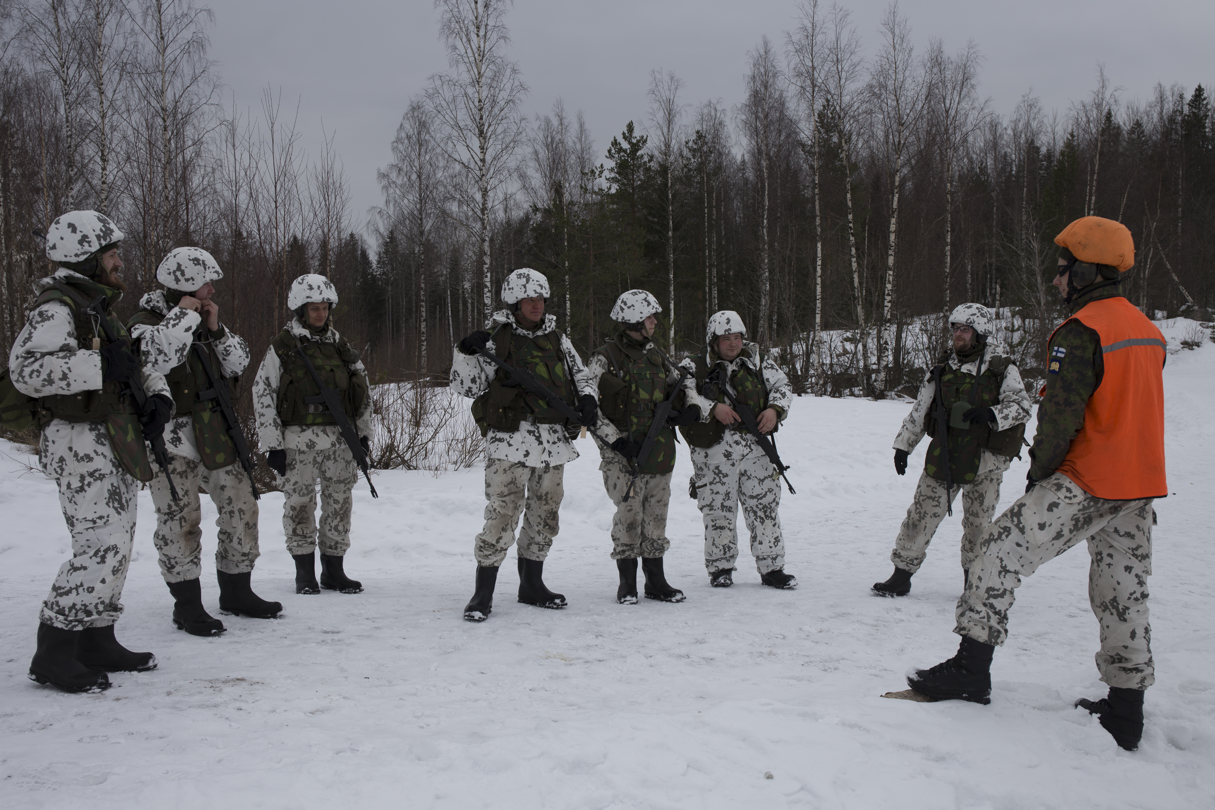 Sotilaita ja oranssiliivinen kouluttaja