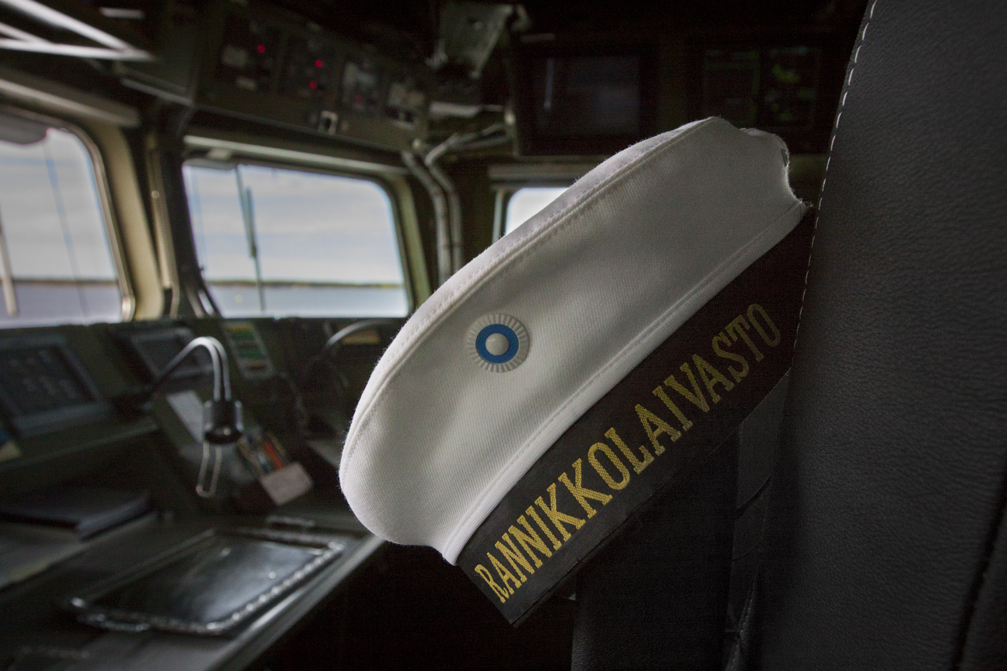 Laivan ohjaamossa hattu jossa lukee teksti: rannikkolaivasto
