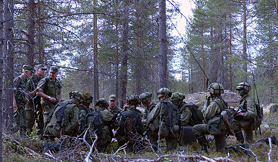 Sotilaista korkeassa polviasennossa metsässä