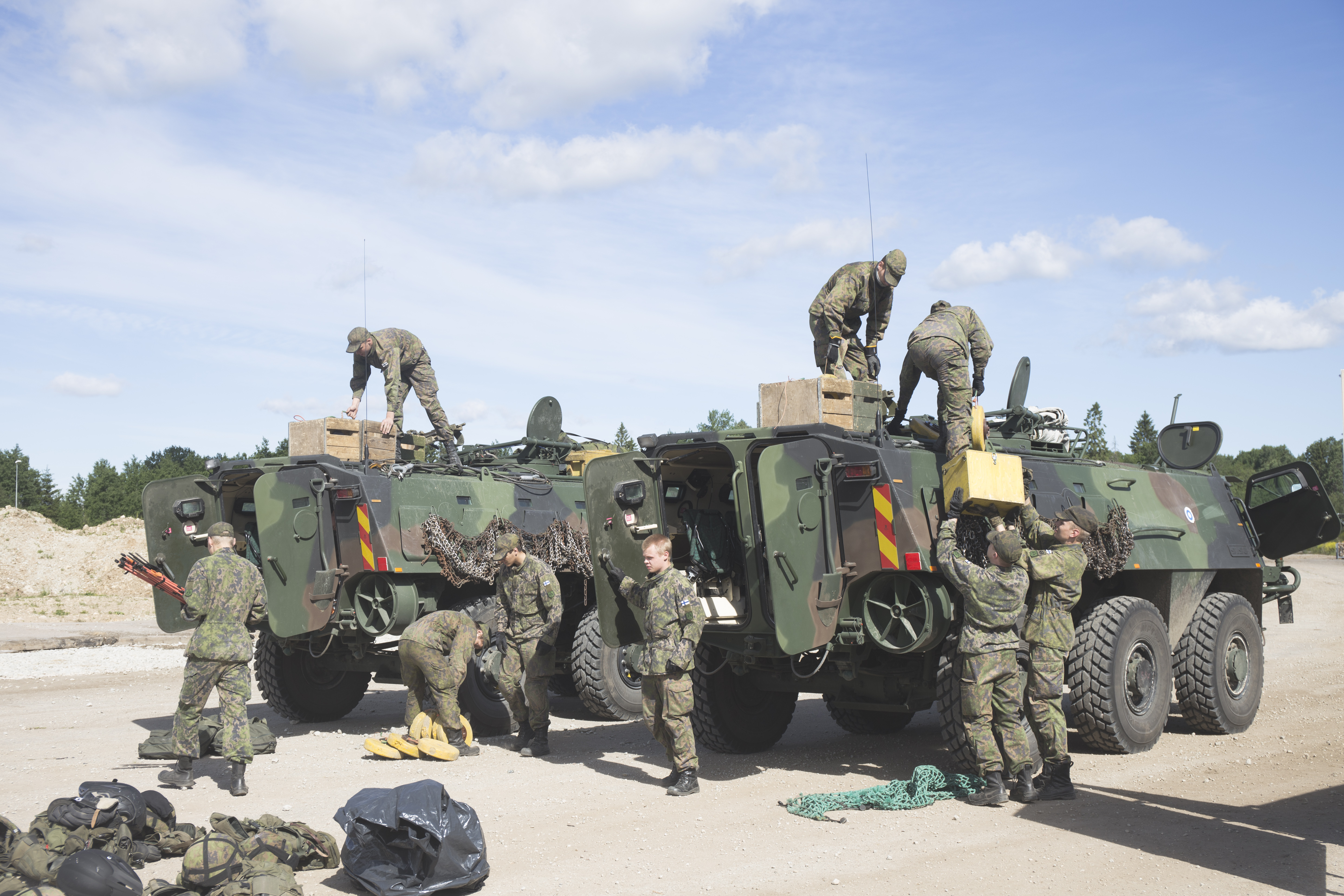 Military men packing equipment for armored vehicles