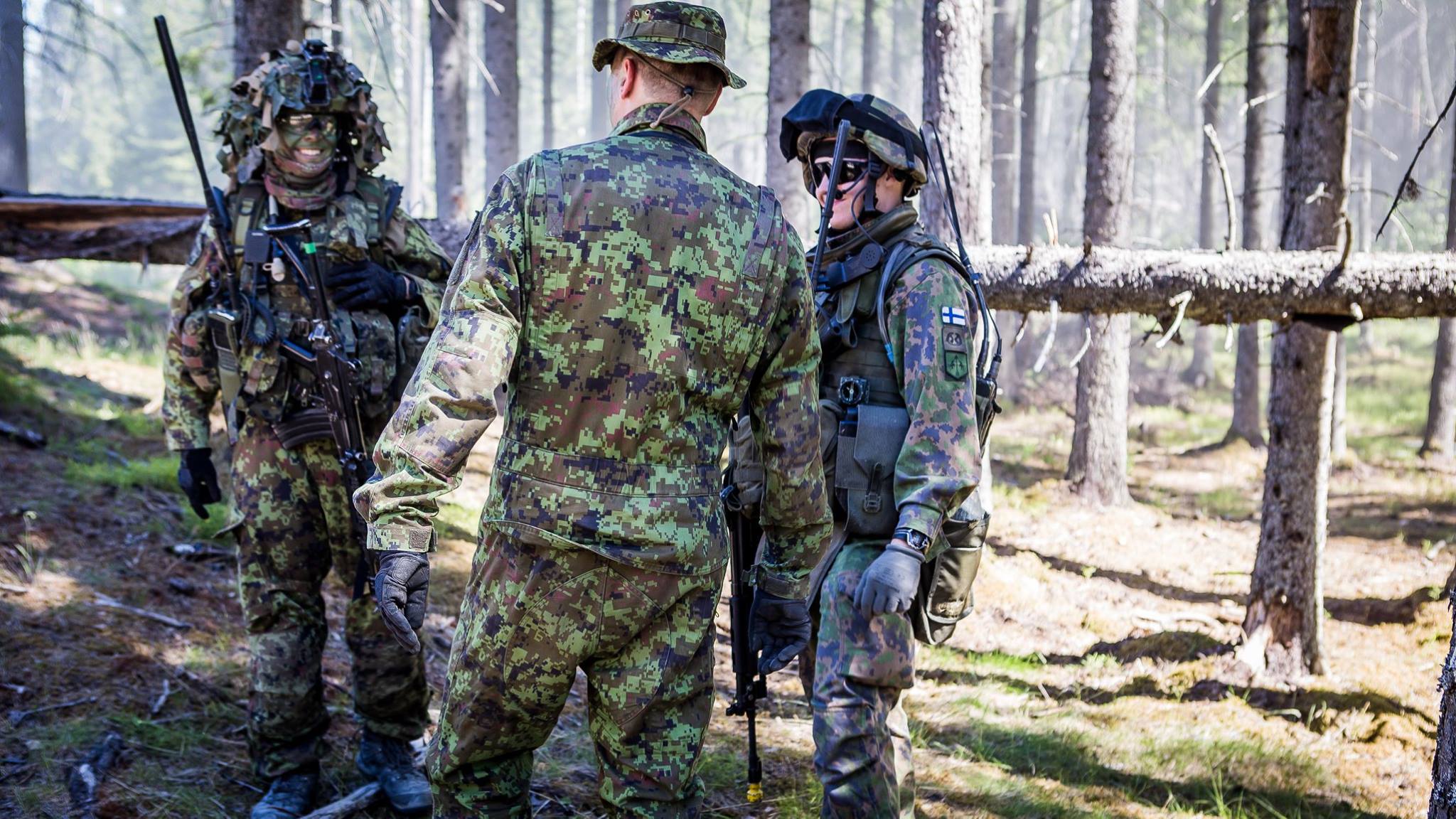 Camoflaged soldiers talking and laughing in the forest