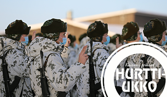 Lumipukuisia alokkaita seisoo asennossa rynnäkkökiväärit selässään käsi valantekoasennossa vannomassa sotilasvalaa talvella. Alokkailla on siniset maskit kasvojensa suojana.