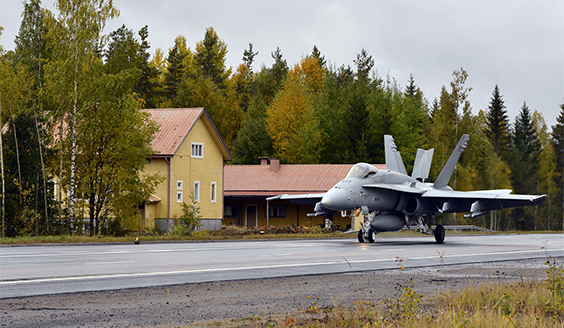 Hornet rullaa maantietukikohdassa, vieressä taustalla keltainen talo