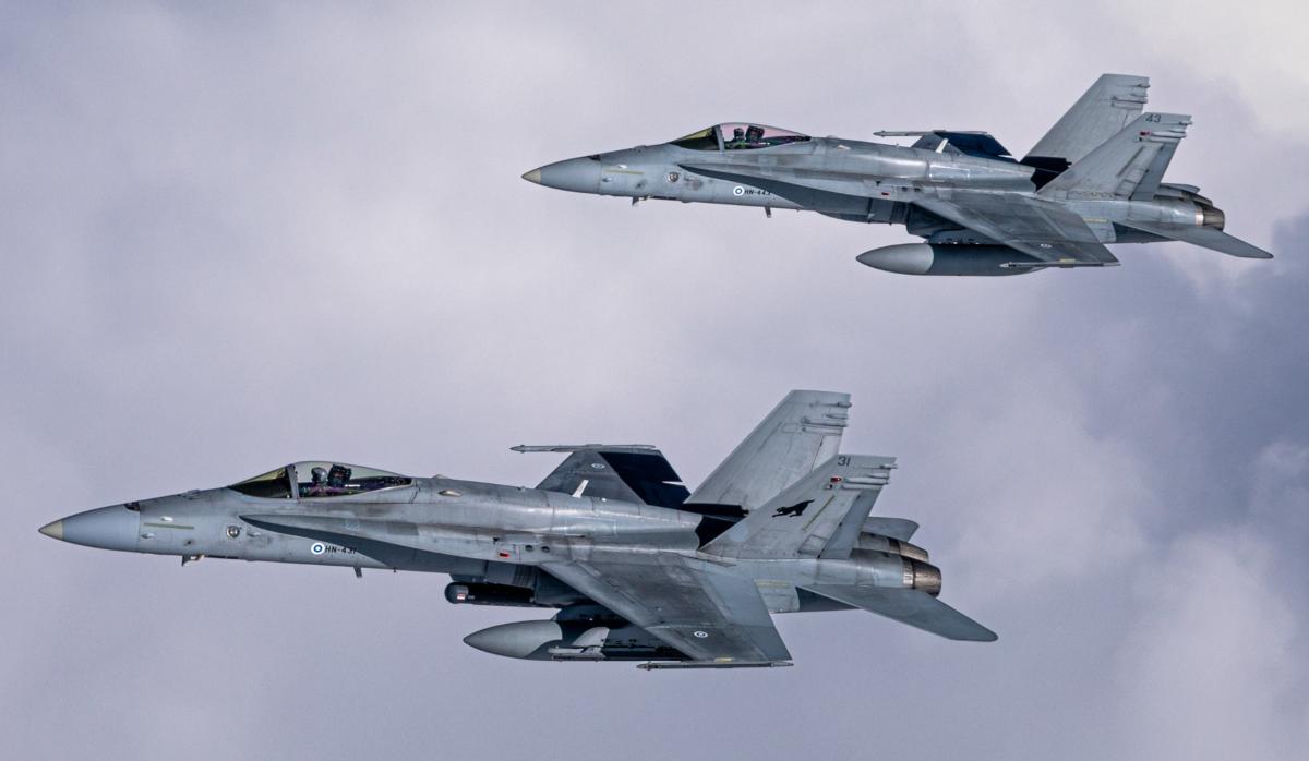 Kaksi F/A-18 Hornet -hävittäjää lentää pilvisellä taivaalla
