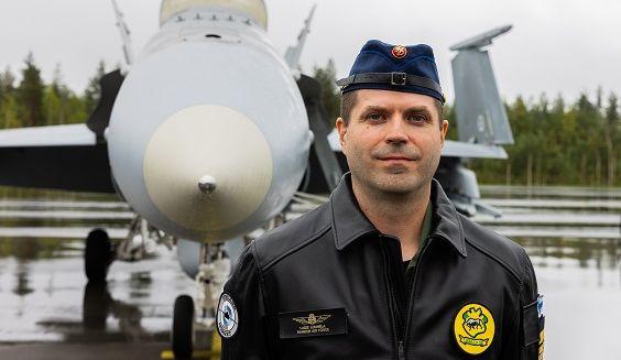 Lähikuva everstiluutnantti Lasse Louhelasta takanaan Hornet-hävittäjä lentokenttäalueella suoraan edestäpäin kuvattuna.