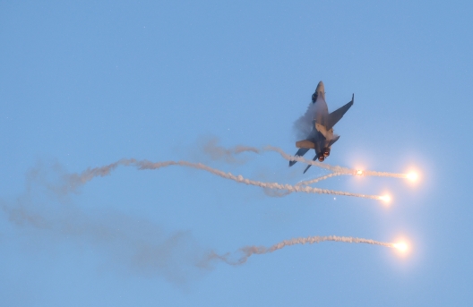The Air Force's F/A-18 Hornet multirole fighter releases flares into the sky during an air show display.