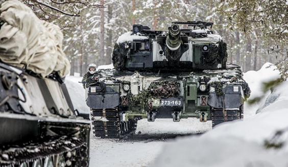 kuva, jossa Leopard 2a4 -taistelupanssarivaunu ajaa lumisissa olosuhteissa tiellä.
